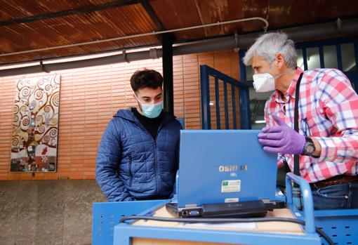 Un alumno recoge un equipo informático