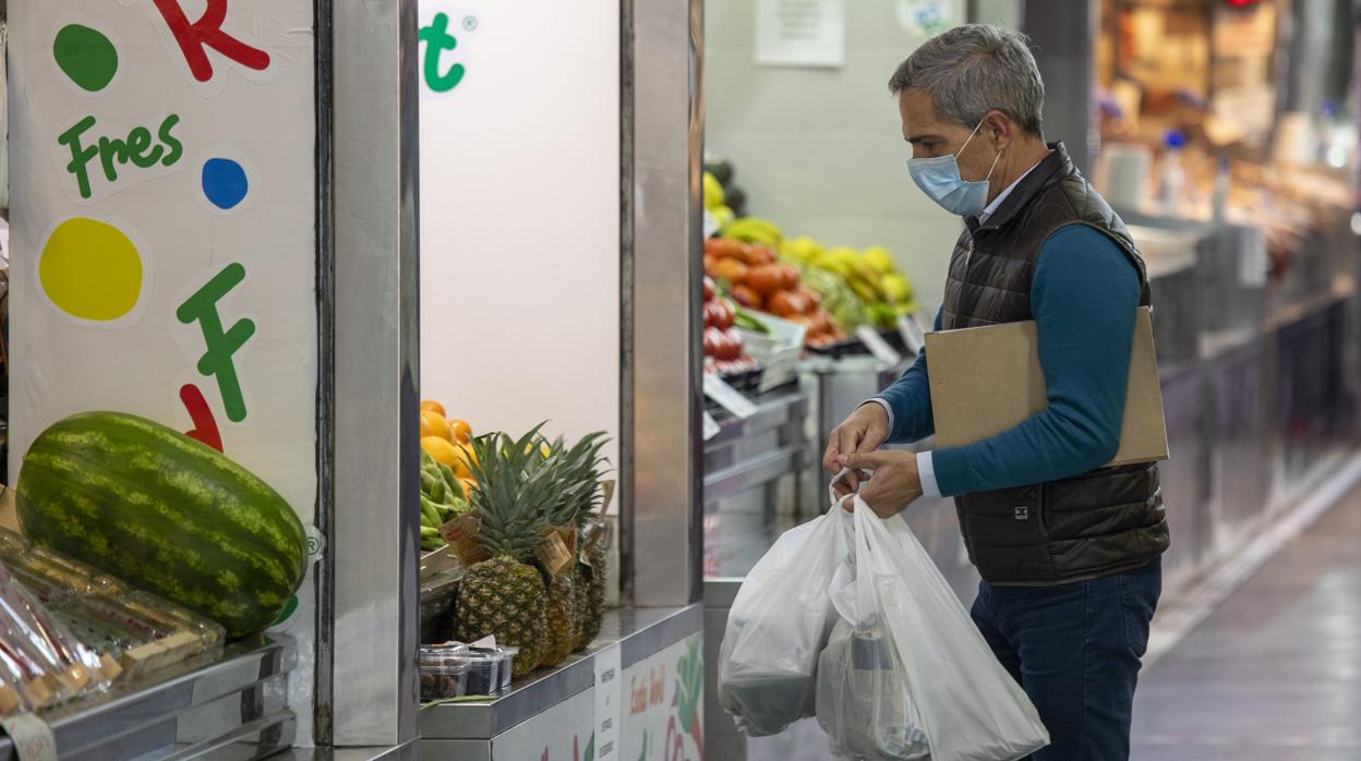 Un cliente hace la compra en un mercado de Huelva