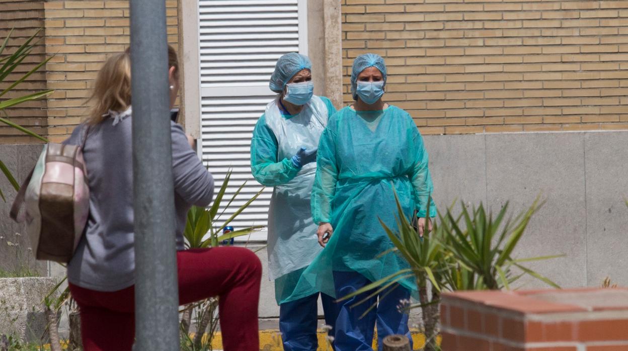 Dos trabajadoras con equipos de protección en el exterior del Hospital Virgen del Rocío de Sevilla