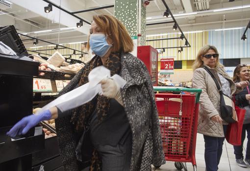 Imagen de una clienta con mascarilla en un supermercado