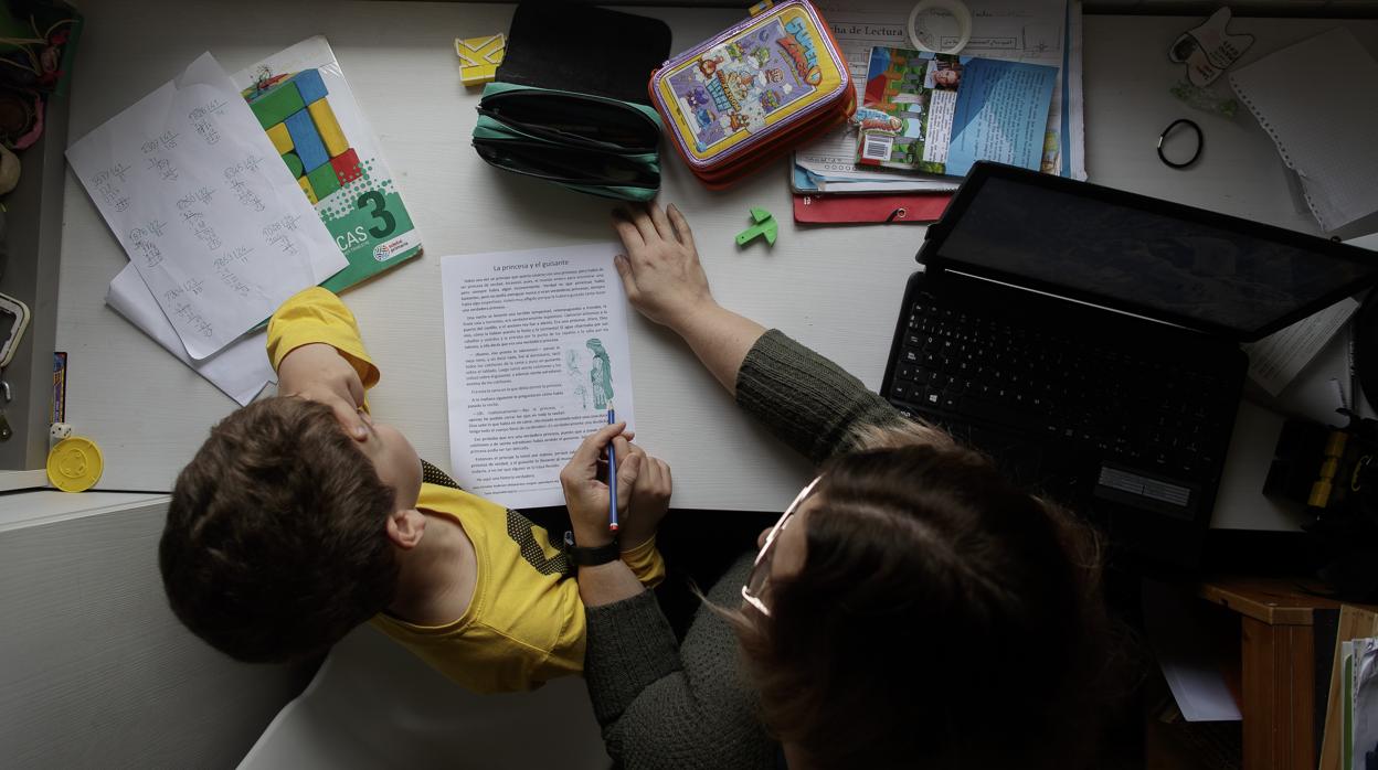 Una madre ayuda a su hijo a estudiar en casa