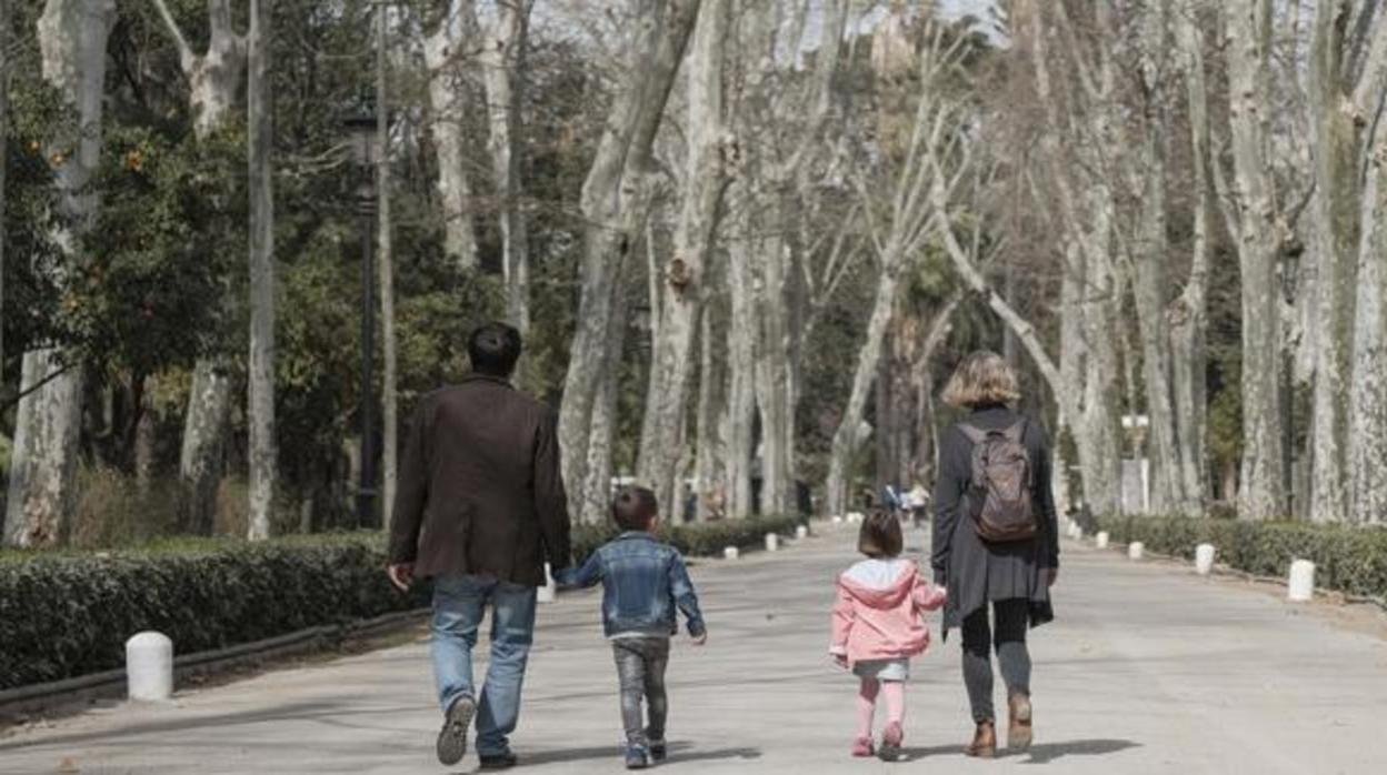 Dos niños pasean con sus padres en el parque de María Luisa de Sevilla