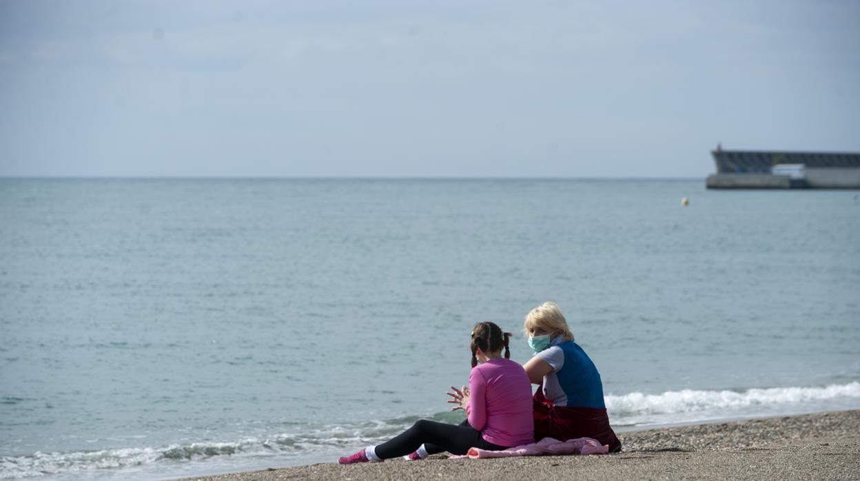 Una madre con su hijo en la Playa de la Malagueta en Málaga