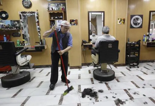 Rafael limpia su peluquería en Sagunto antes de atender a un cliente