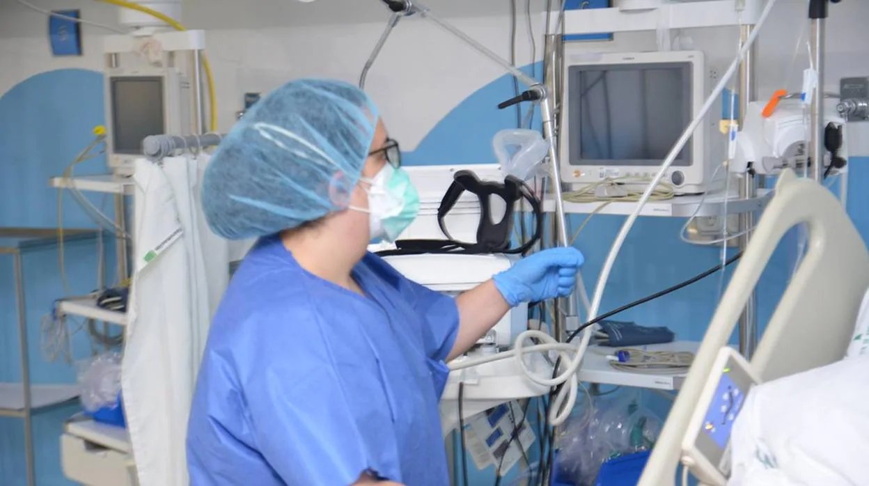 Una profesional sanitaria del Reina Sofía atiende a un paciente de covid-19