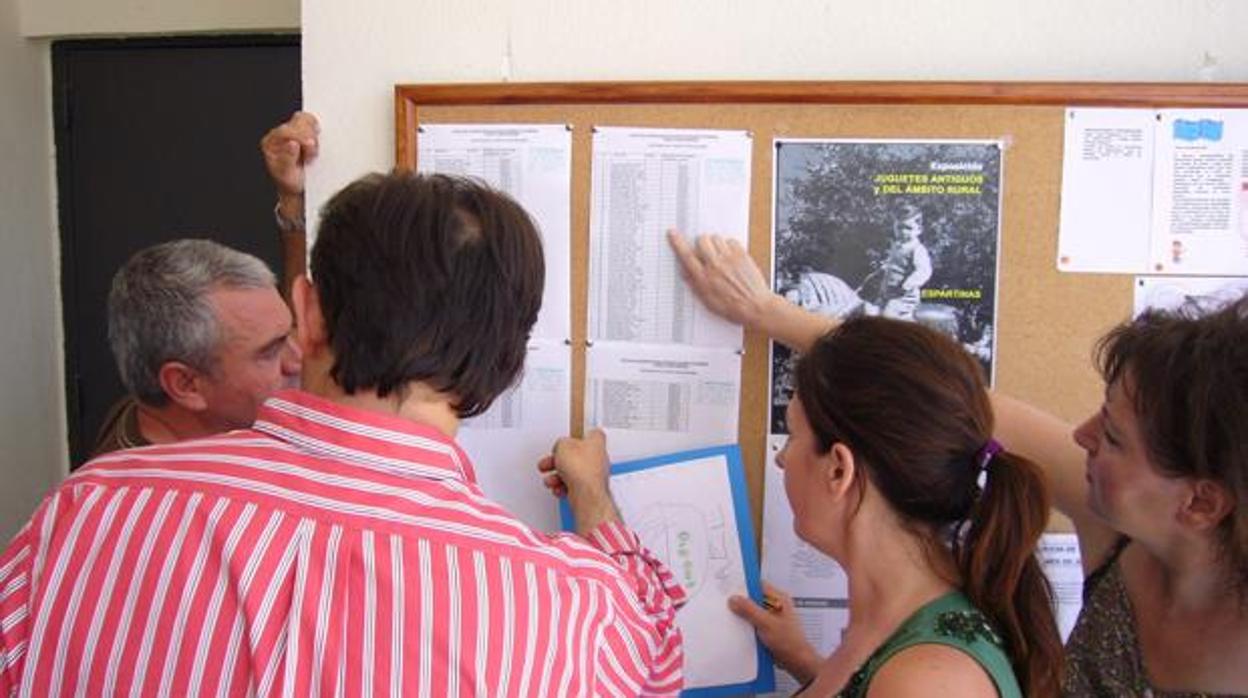 Padres consultan las listas de escolarizacion en una imagen de archivo