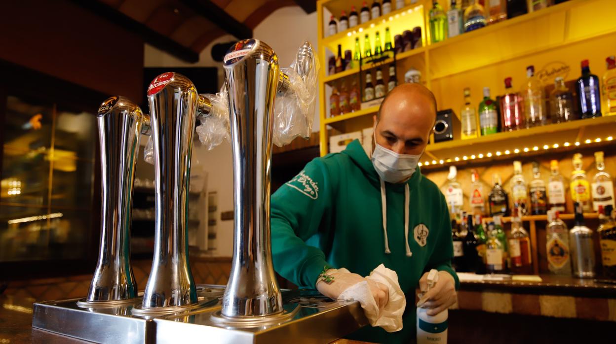 Un hostelero pone a punto la barra del bar para la reapertura