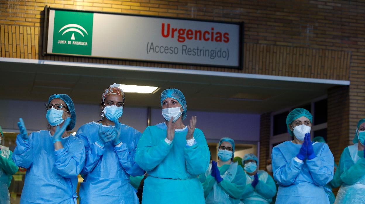 Personal sanitario aplaude en la puerta de Urgencias del Hospital Virgen del Rocío de Sevilla