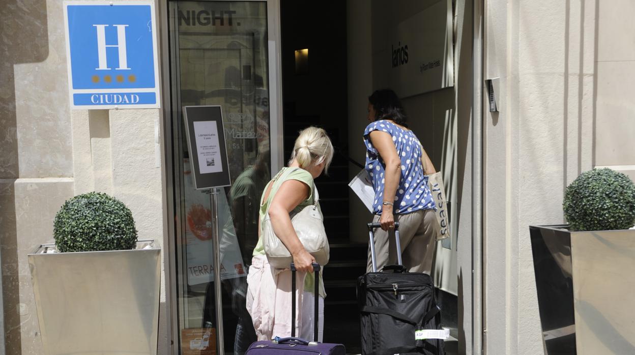 Dos turistas entran en un hotel de la capital malagueña antes del estallido de la crisis