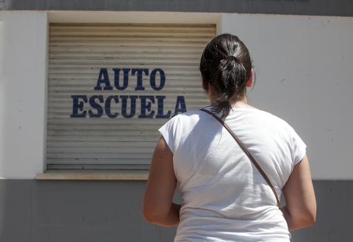 Una joven delante de una autoescuela