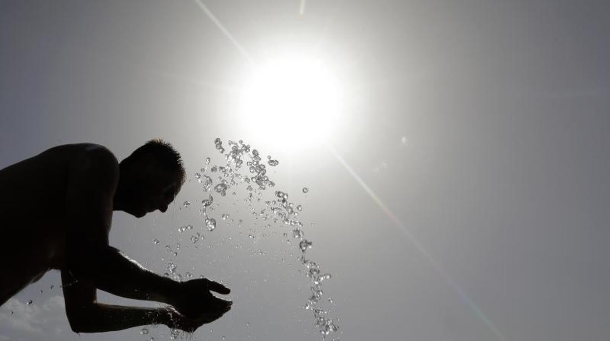 Un hombre se refresca en Córdoba en una jornada de intenso calor