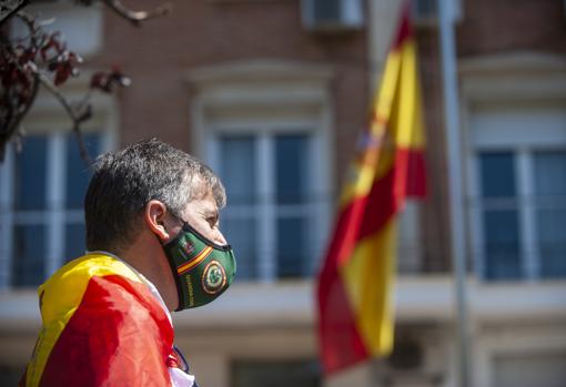 Mascarillas y banderas con los símbolos de la Guardia Civil entre los asistentes