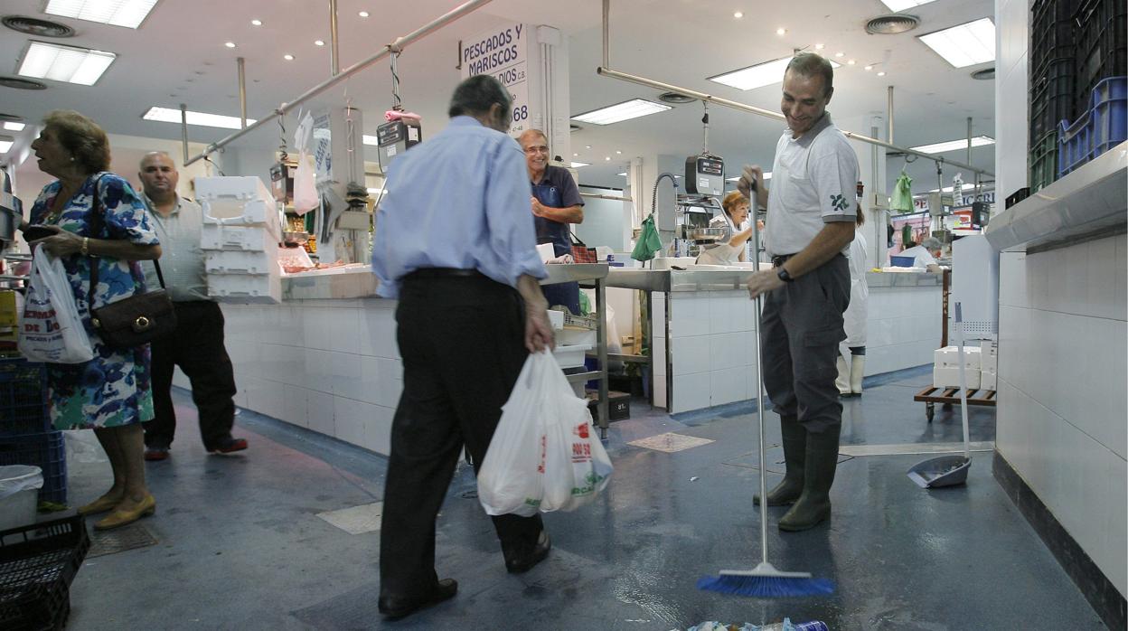 Un limpiador barre en el mercado de Ciudad Jardín