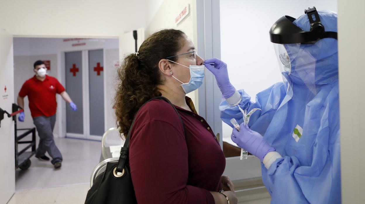 Una frofesional sanitaria del hospital de Cruz Roja en Córdoba hace una prueba a una mujer antes de operarse