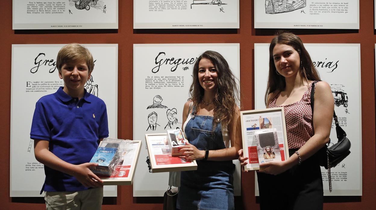 Los tres ganadores del concurso fotográfico de ABC posan con sus premios y una réplica de la página del periódico informando del resultado final