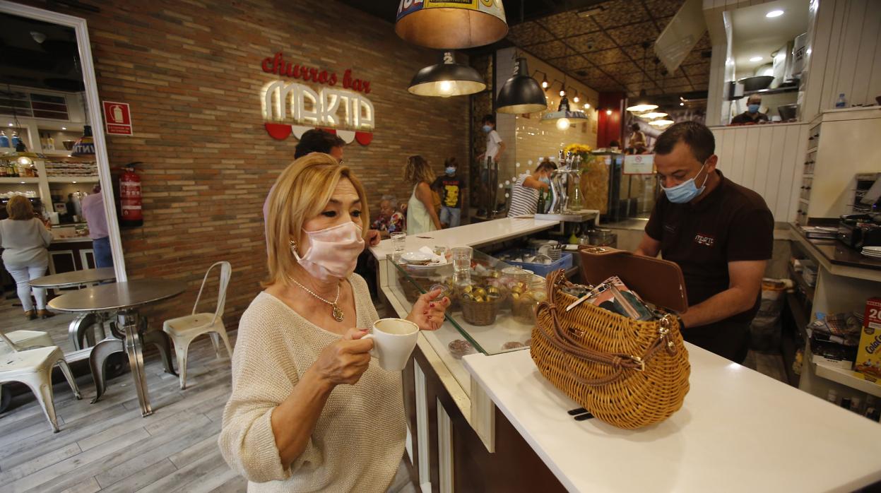 Una mujer desayuna en la barra de una cafetería del centro de la ciudad