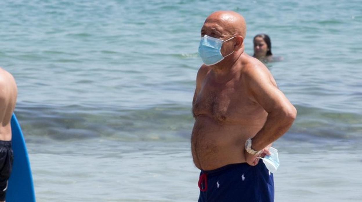 Un hombre con mascarilal junto al mar en Málaga