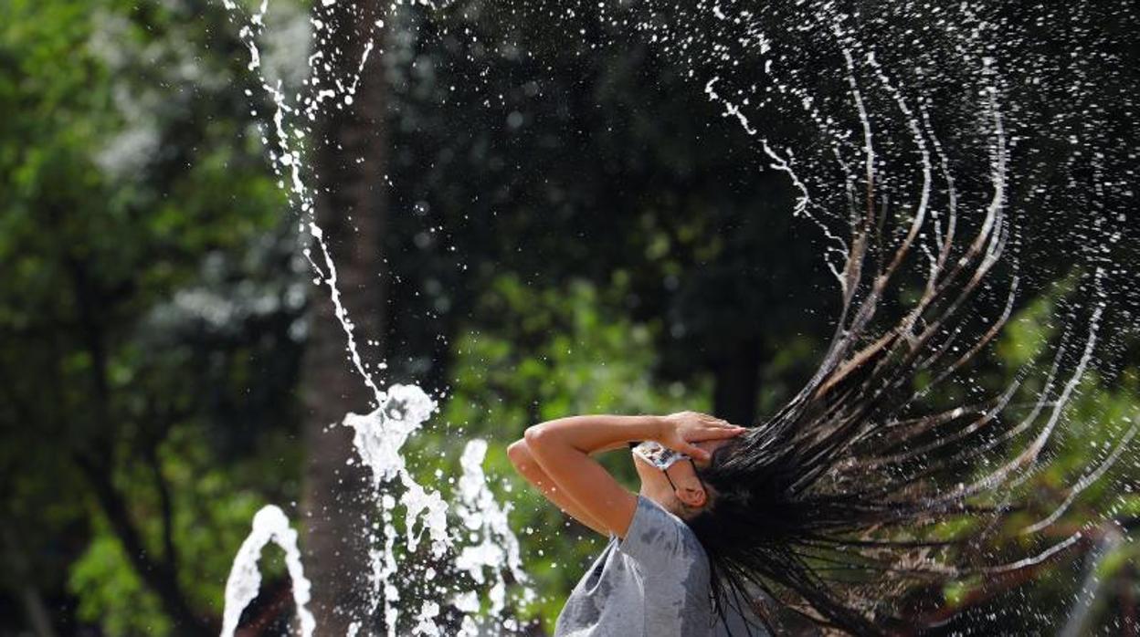 Una joven se refresca en una fuente de Córdoba en la jornada de ayer