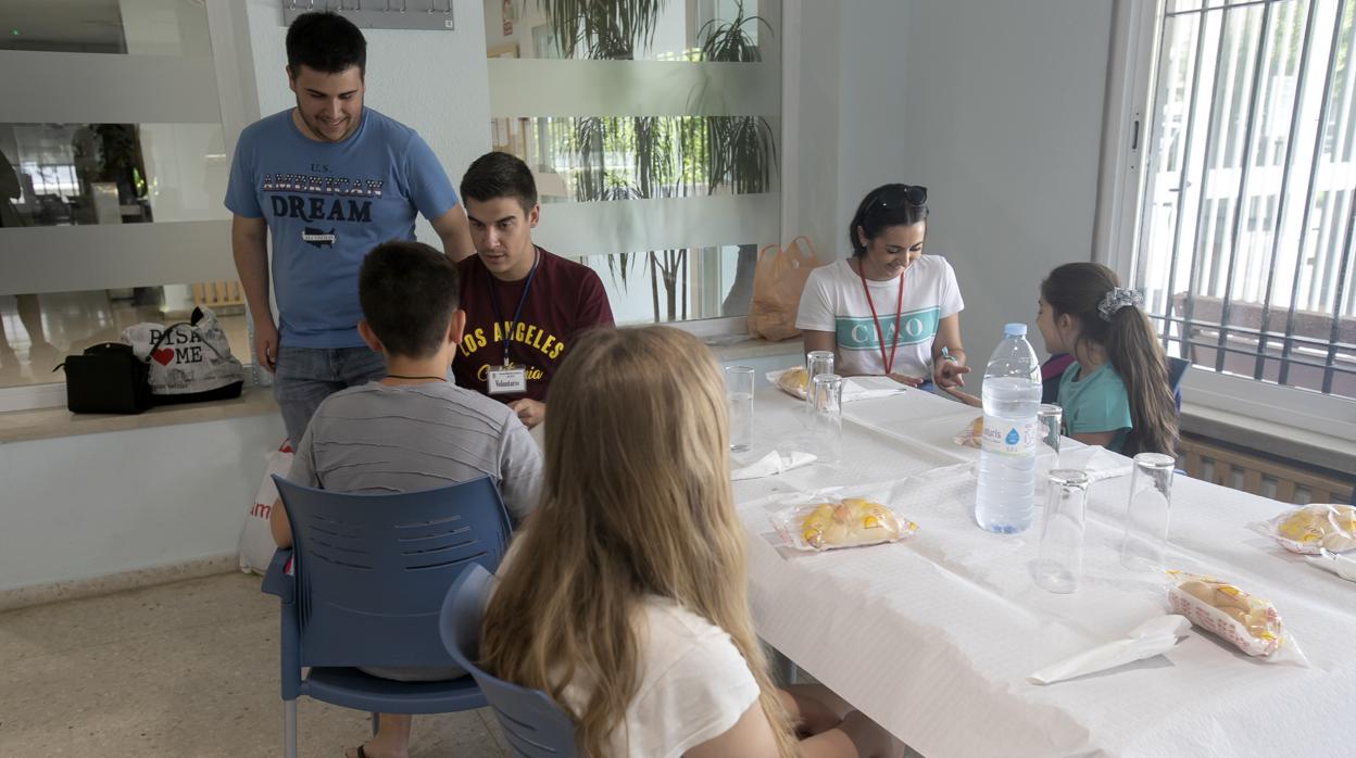 Un grupo de jóvenes espera el almuerzo en un comedor social