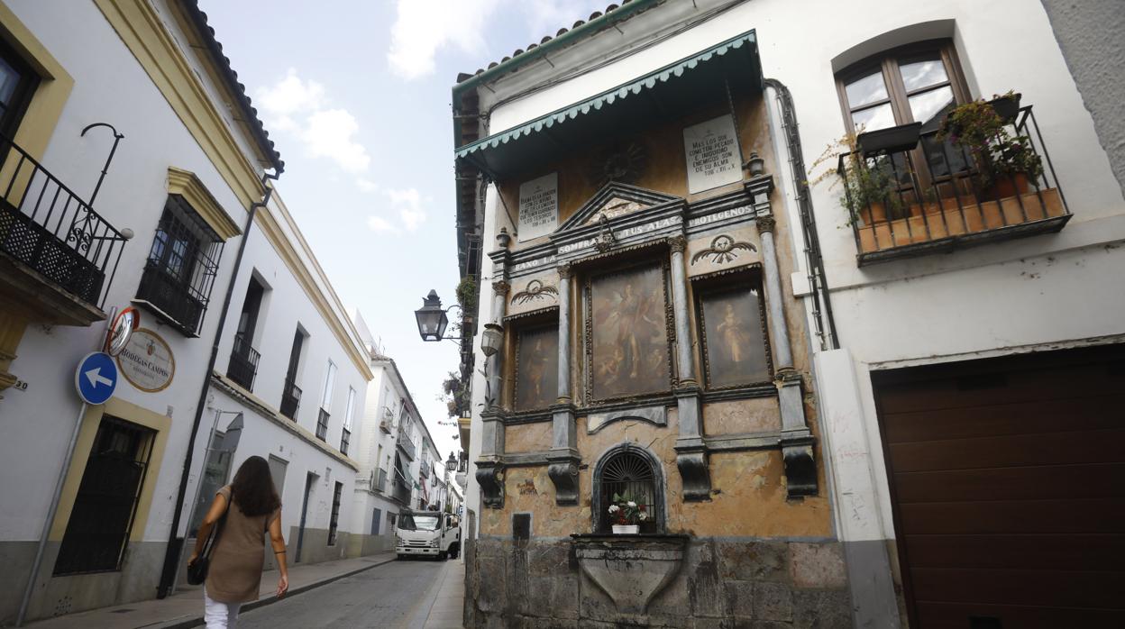 Una mujer delante del altar de la calle Lineros