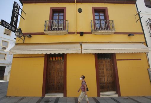 Un viandante junto a un hotel del casco histórico, cerrado tras el confinamiento