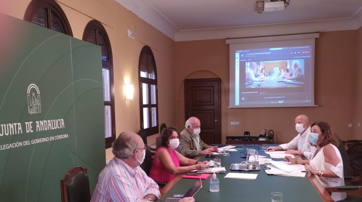 Lo consejeros de Salud y Educación, al fondo de la mesa de reunión