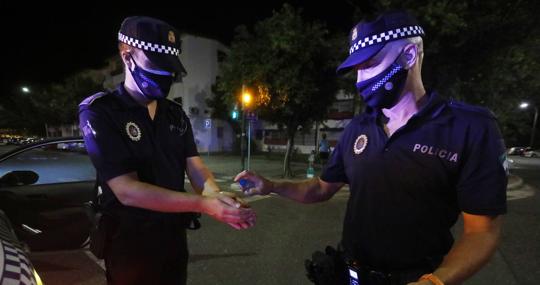 Un agente aplica gel desinfectante a su compañero tras una intervención