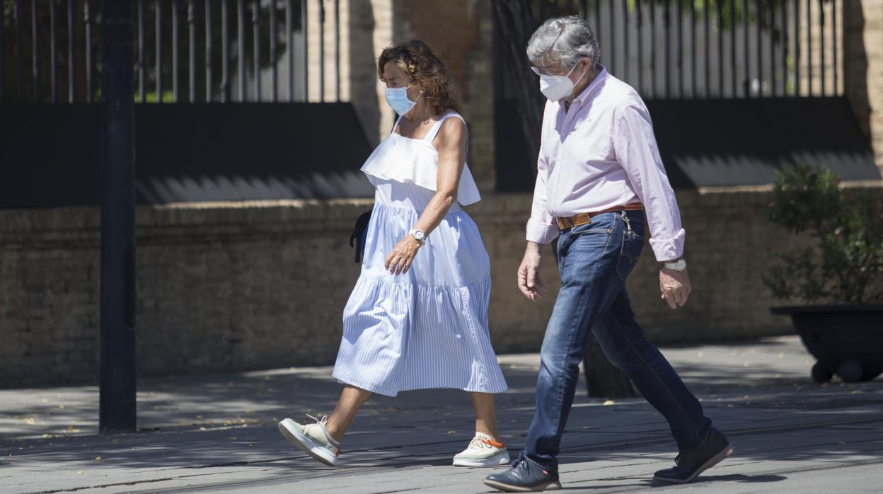 Dos personas caminan por la capital andaluza con mascarillas para prevenir contagios de Covid-19