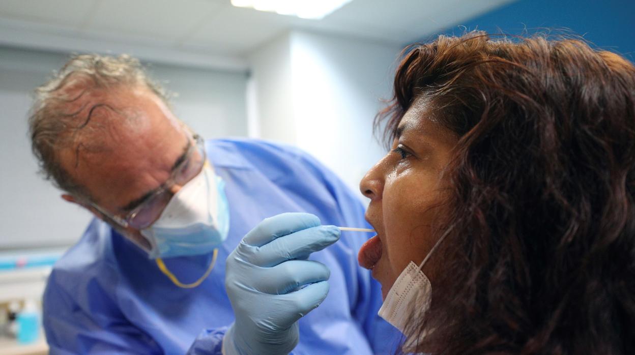 Un sanitario toma muestras para una PCR a una mujer