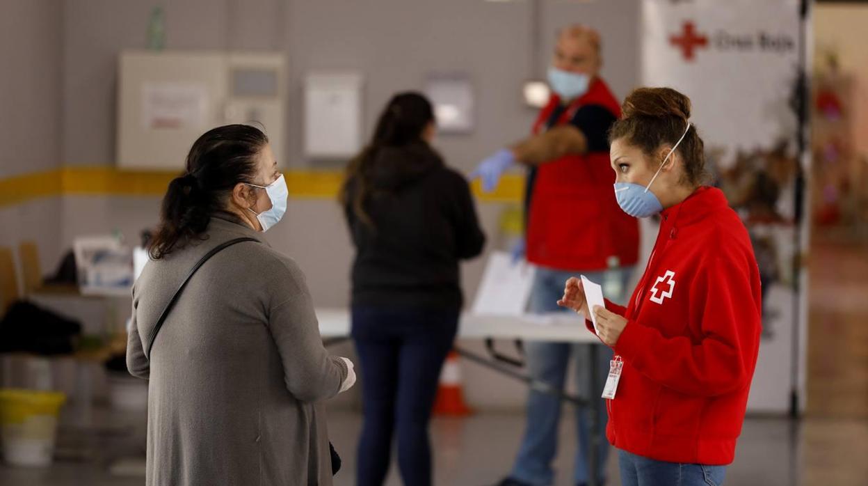 Una voluntaria de Cruz Roja atiende a una señora en Córdoba