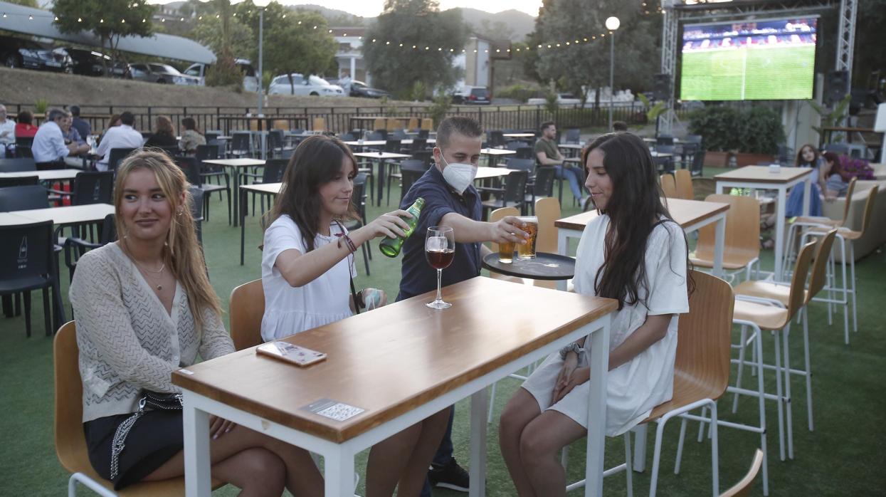 Tres jóvenes, en una terraza de verano de la capital