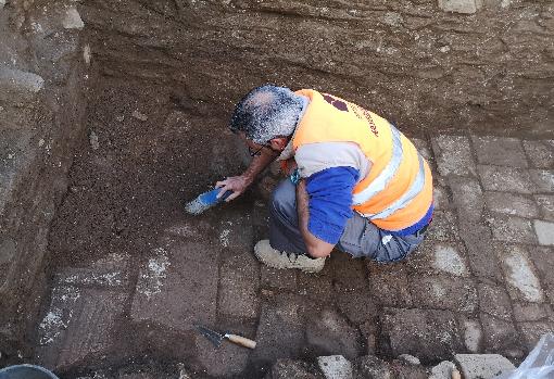 Un arqueólogo desentierra las baldosas de un suelo perfectamente conservado