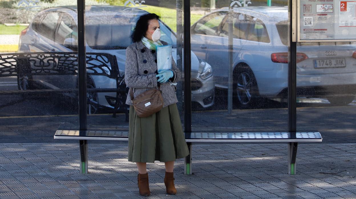 Una mujer espera al bus en una parada de Fátima