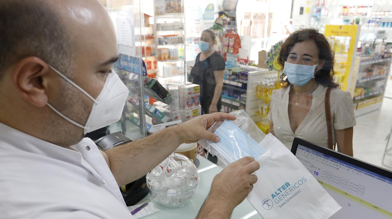 Un boticario despacha mascarillas