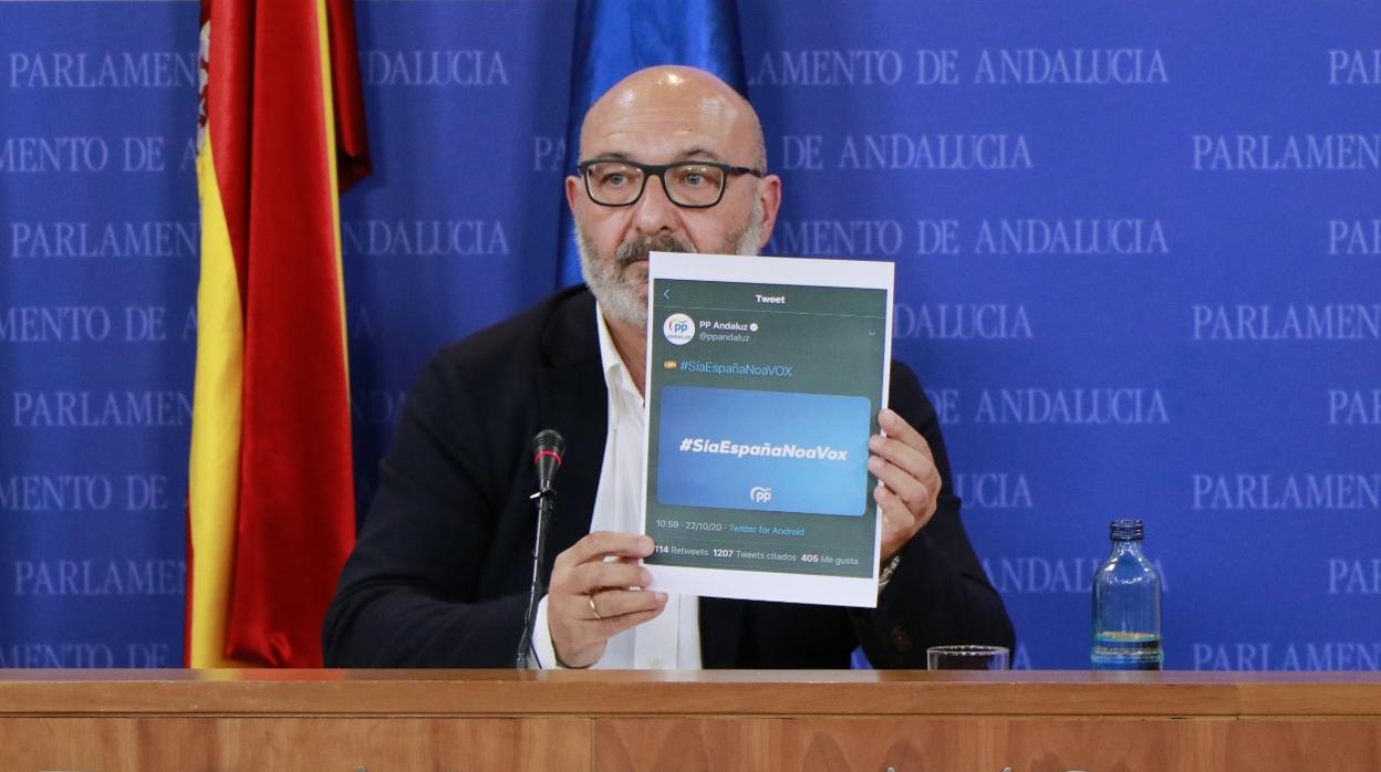 Alejandro Hernández, durante su comparecencia, muestra la campaña que ha lanzado el PP este jueves en su contra en las redes sociales y que luego ha retirado