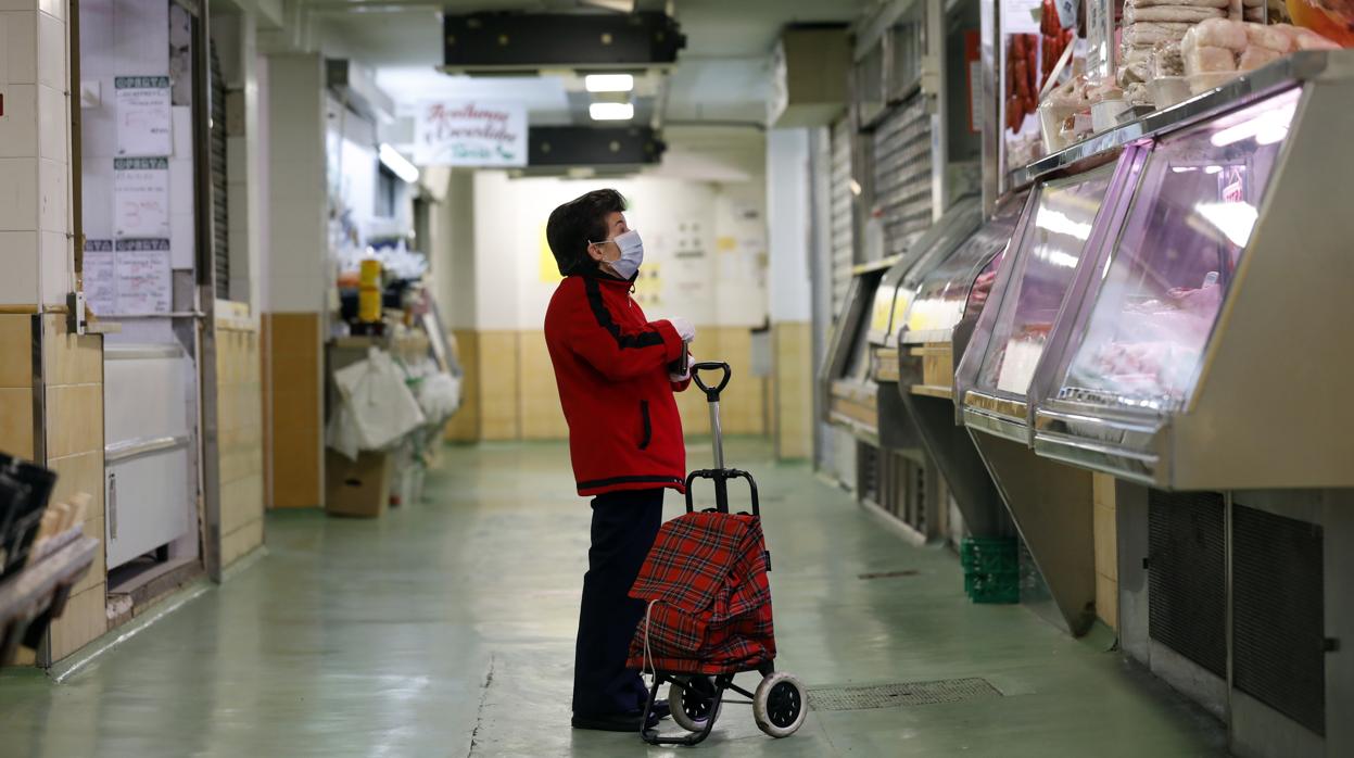 Una señora realiza la compra en una carnicería del mercado municipal del Marrubial