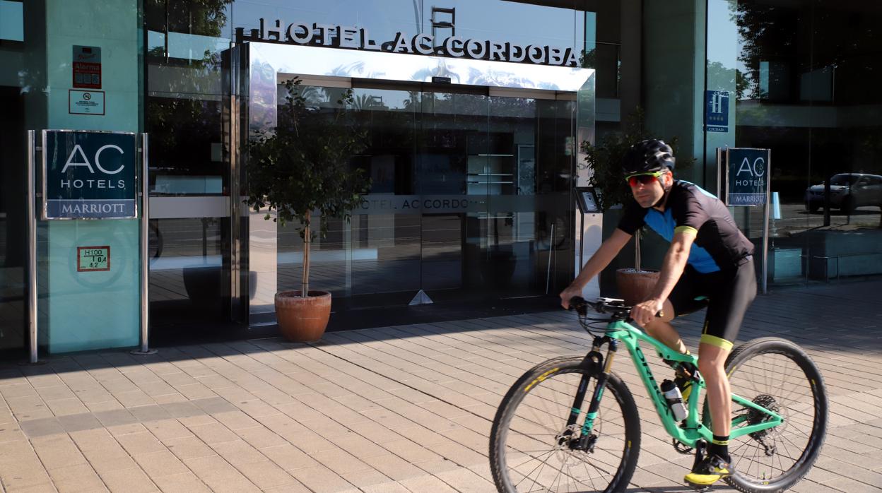 Un ciclista pasa por la entrada del hotel AC Córdoba