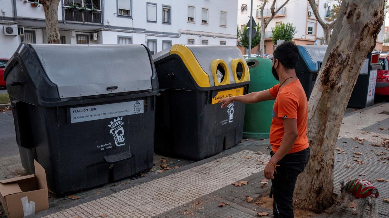 Un hombre ante el contenedor de basura de Huelva donde se halló la bolsa de basura con restos humanos