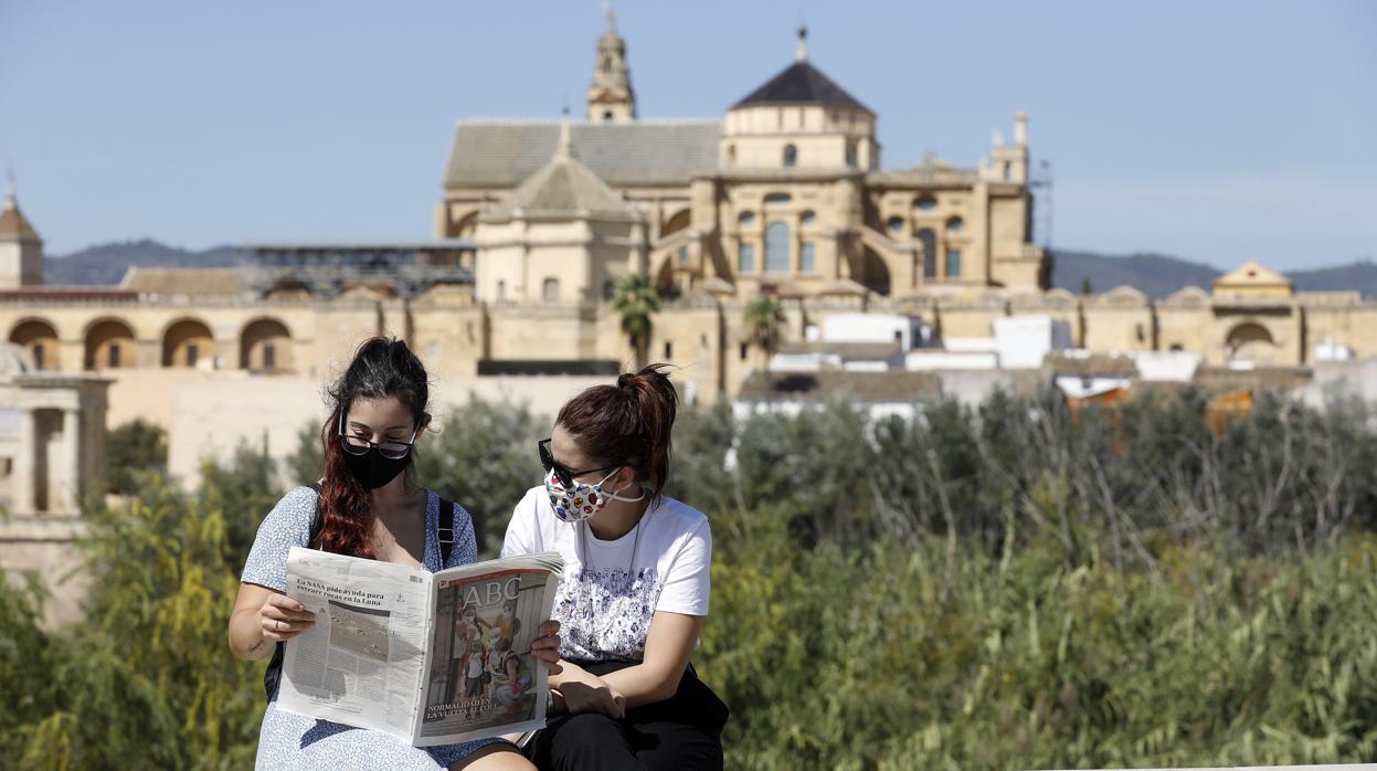 Dos cordobesas disfrutando del diario ABC de Córdoba en una calle de la capital