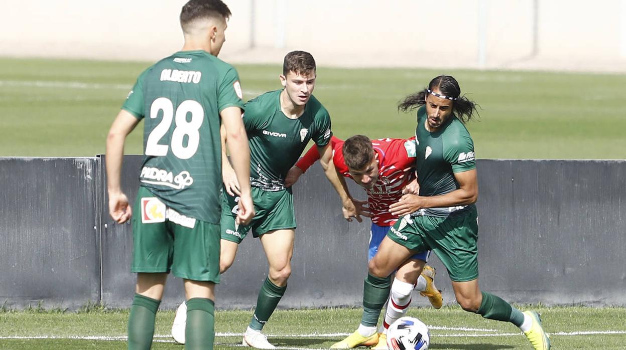 Mario Ortiz y Espeso pugnan por un balón ante un rival