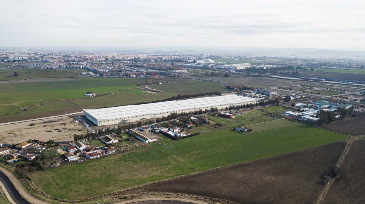 Panorámica aérea de las naves de Colecor frente a los terrenos por urbanizar del Área Logística de Córdoba