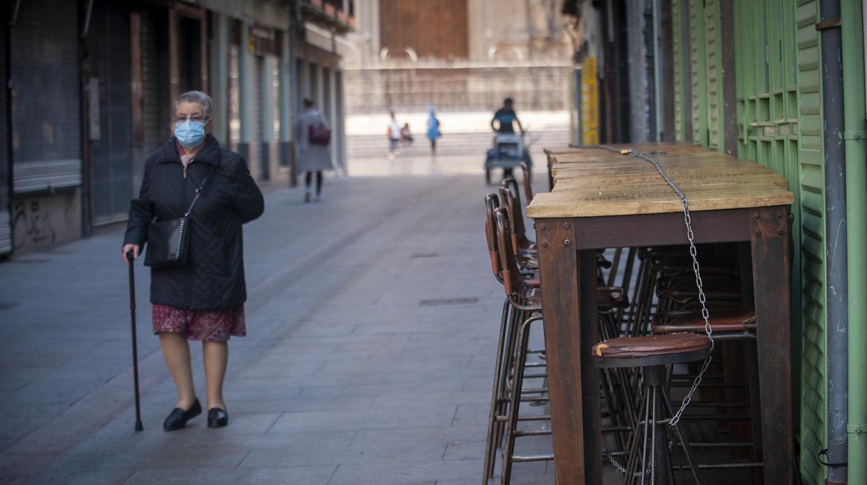 Una señora pasea por una calle de Málaga