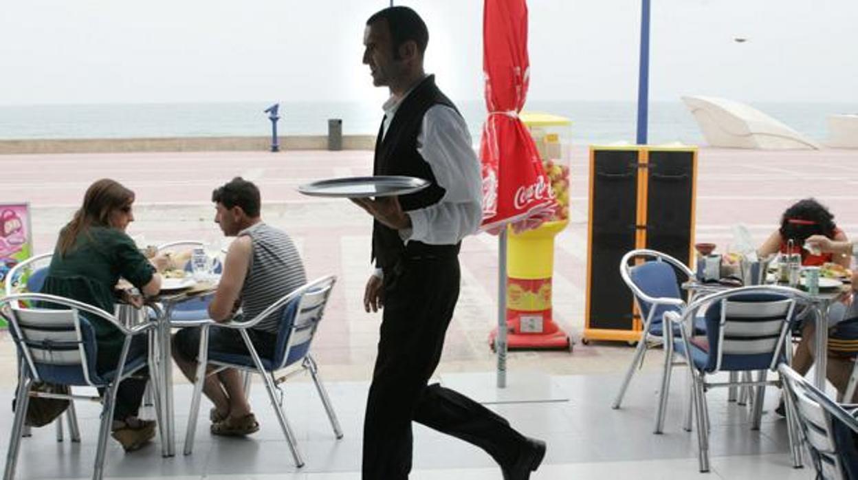 Un camarero atendiendo las mesas de un bar