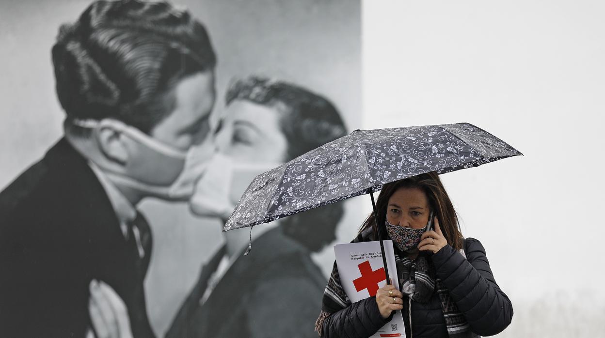 Una mujer se protege de la lluvia con un parauas en Córdoba