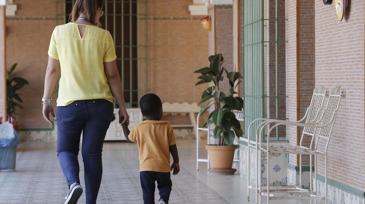 Una monitora del proyecto Ödos con uno de los pequeños acogidos en el centro de Montilla