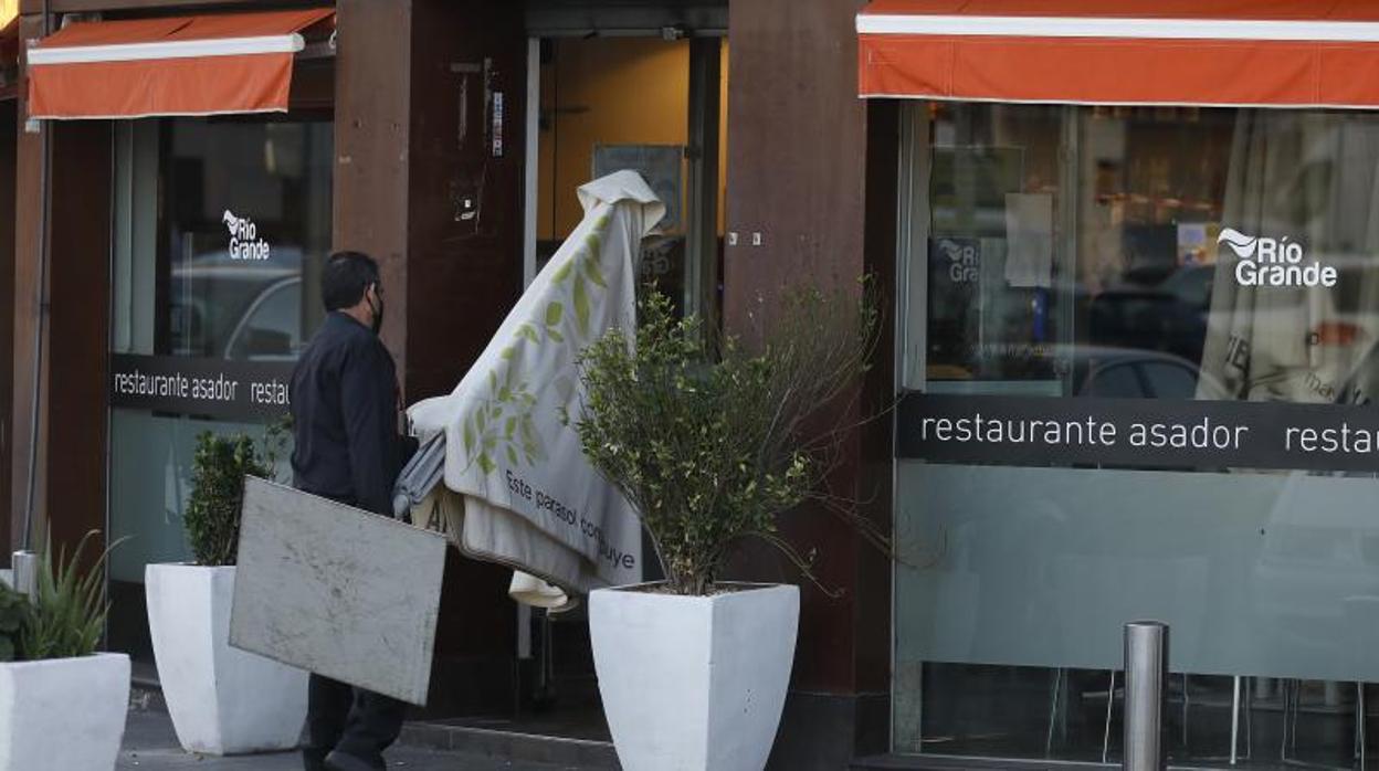 Un trabajador recoge veladores en un restaurante de un polígono industrial cordobés