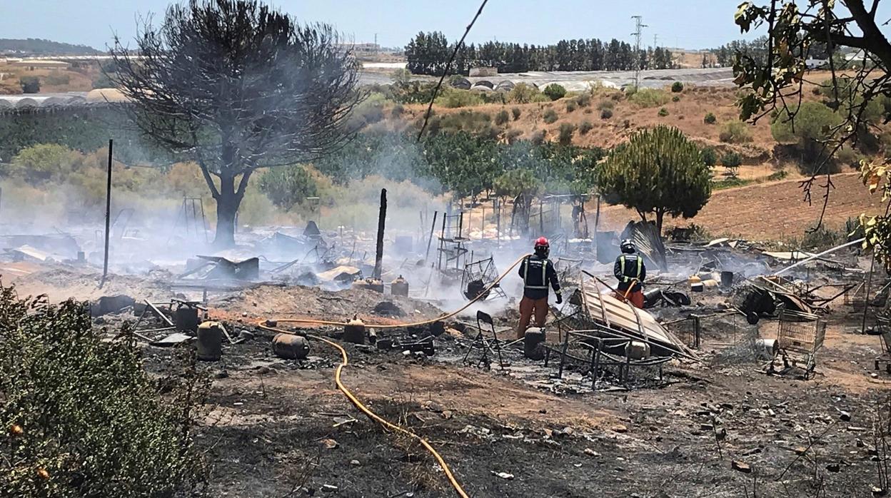 Los bomberos apagan el fuego tras el incendio de un asentamiento chabolista en