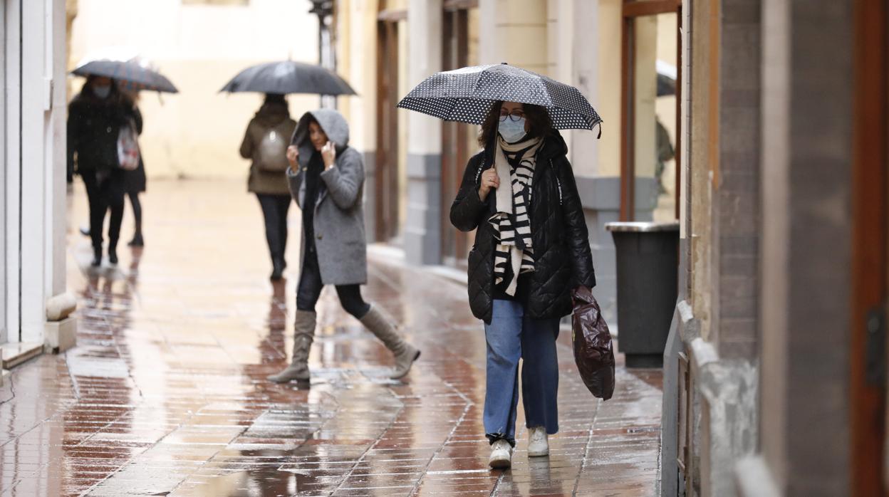 Varias mujeres se refugian de la lluvia en Córdoba este jueves 7 de enero de 2021