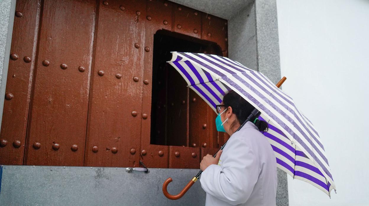 Una mujer de Añora habla con otra a través de una puerta cerrada