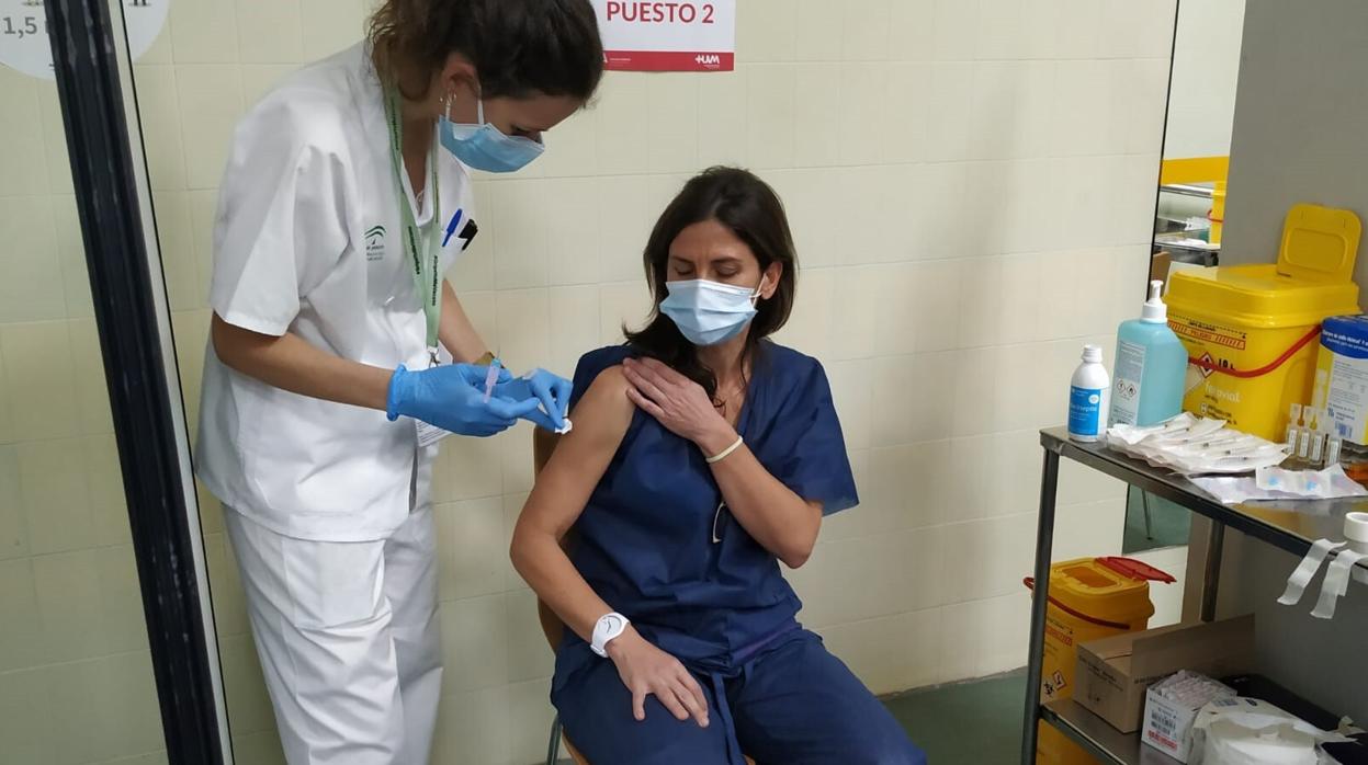 Una enfermera vacuna de Covid-19 a una compañera en el Hspital Virgen Macarena de Sevilla